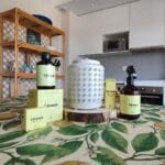 Difusor Bali sobre un tronco de madera decorativo con productos con aroma de citronela en la cocina.