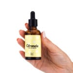 Esencia 50ml para difusor de Citronela Antimosquitos. Bote de cristal sujetado por una mano de mujer